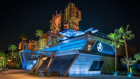 Avengers Headquarters shown lit at night at Avengers Campus.