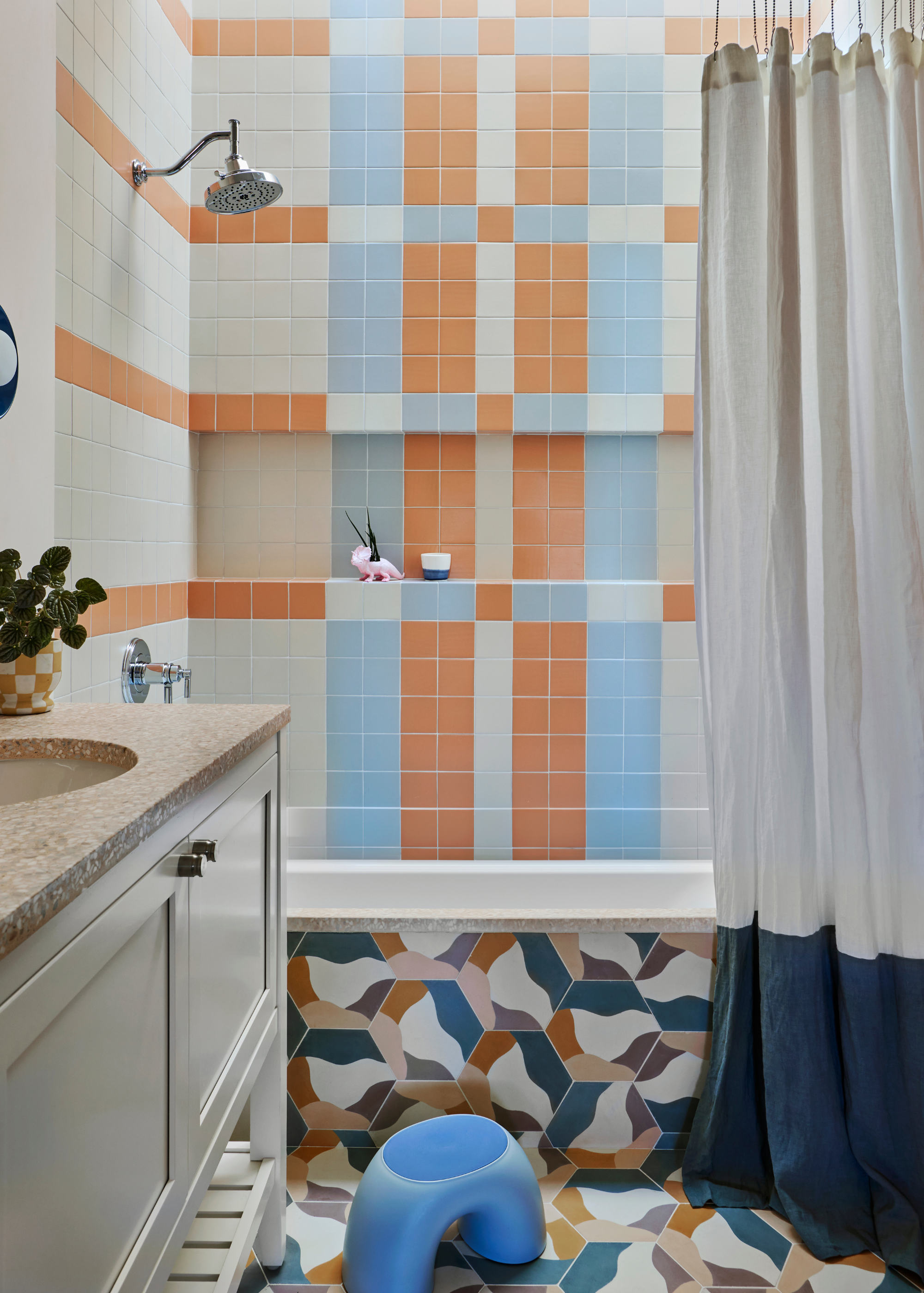 a blue and orange woven tile design in a bathroom with a built in bath
