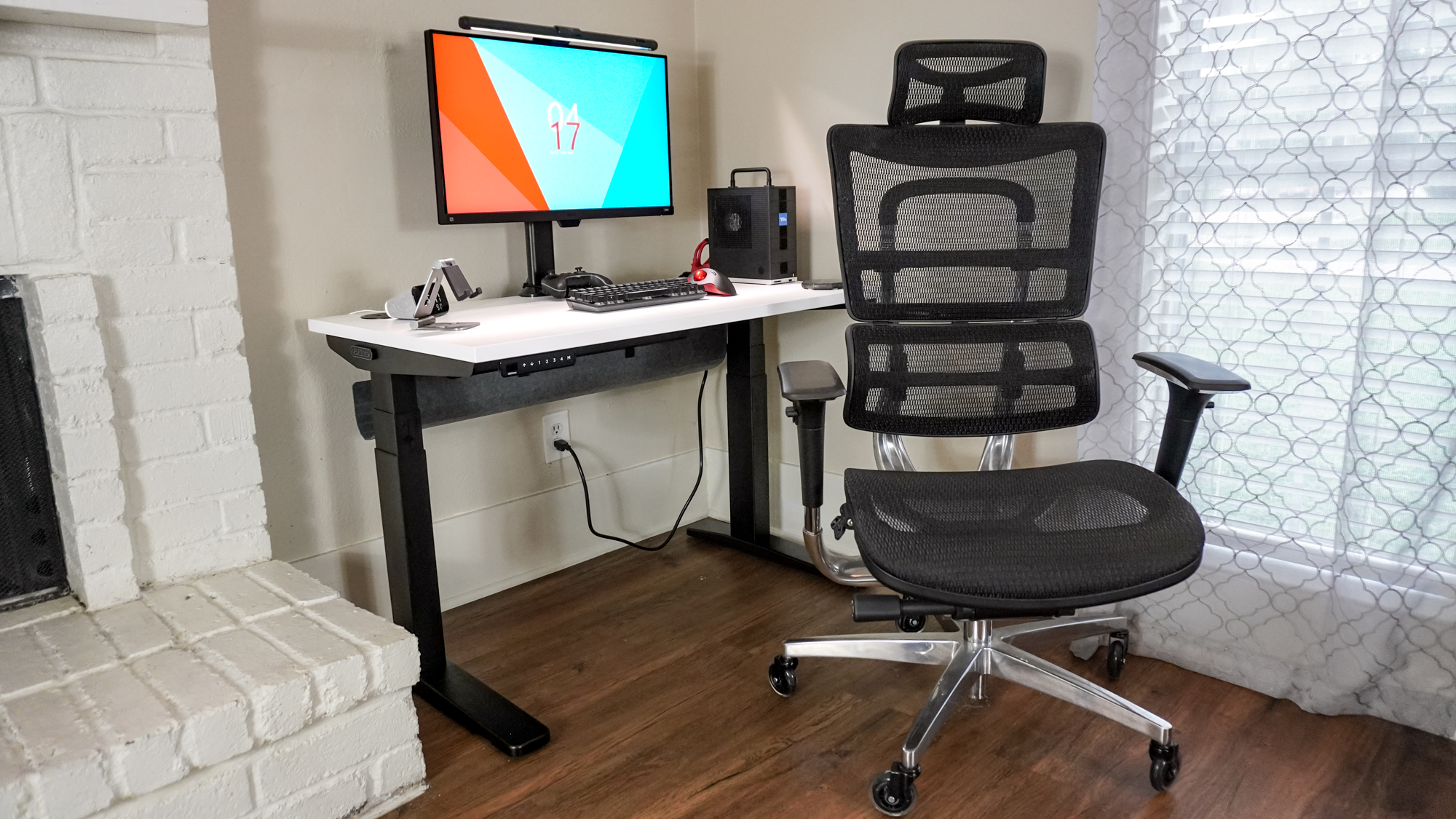 The Uplift V3 standing desk set up in a corner with an office chair in front of it