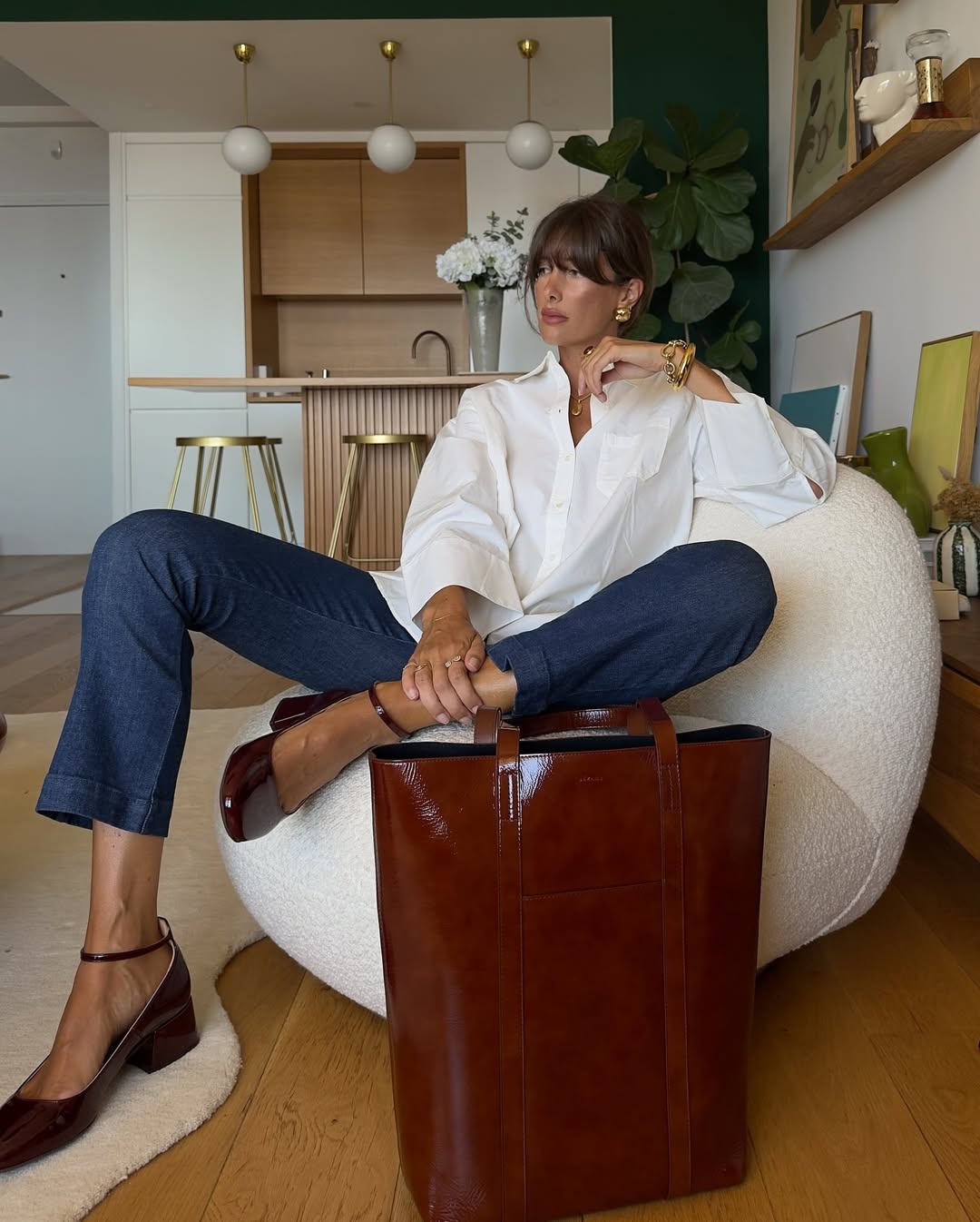 @juliesfi wears a white button-up shirt, blue jeans and burgundy Mary-Janes