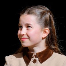 Princess Charlotte wearing a brown coat and smiling