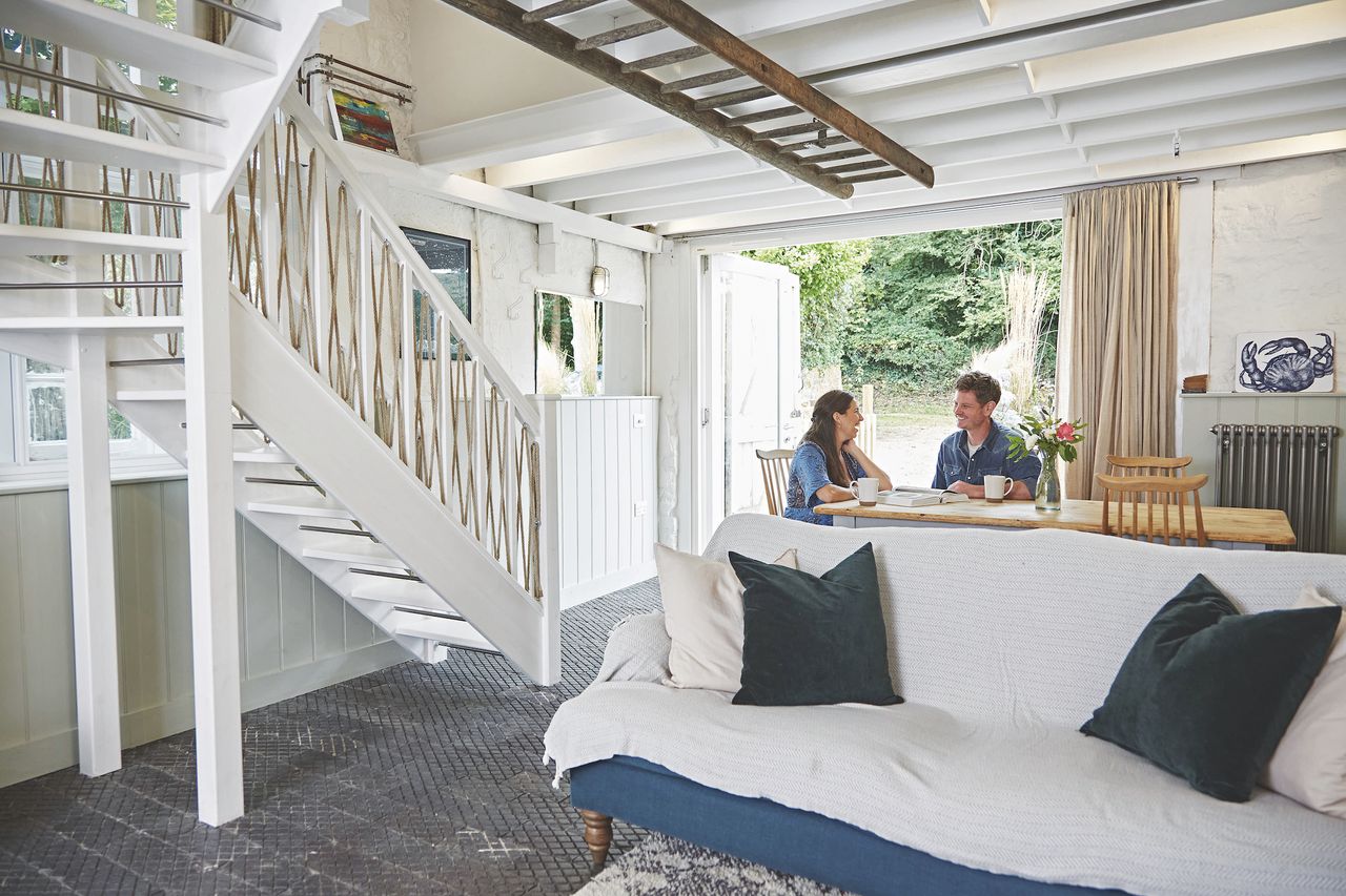 living room in white garage conversion with people sat at dining table