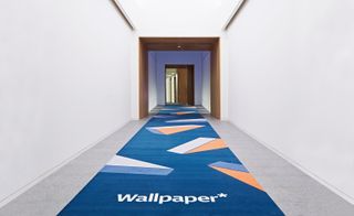 Entrance hallway rolled out in wallpaper as a blue carpet for guests