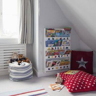kids play room with white wall and toy bag with red cushion