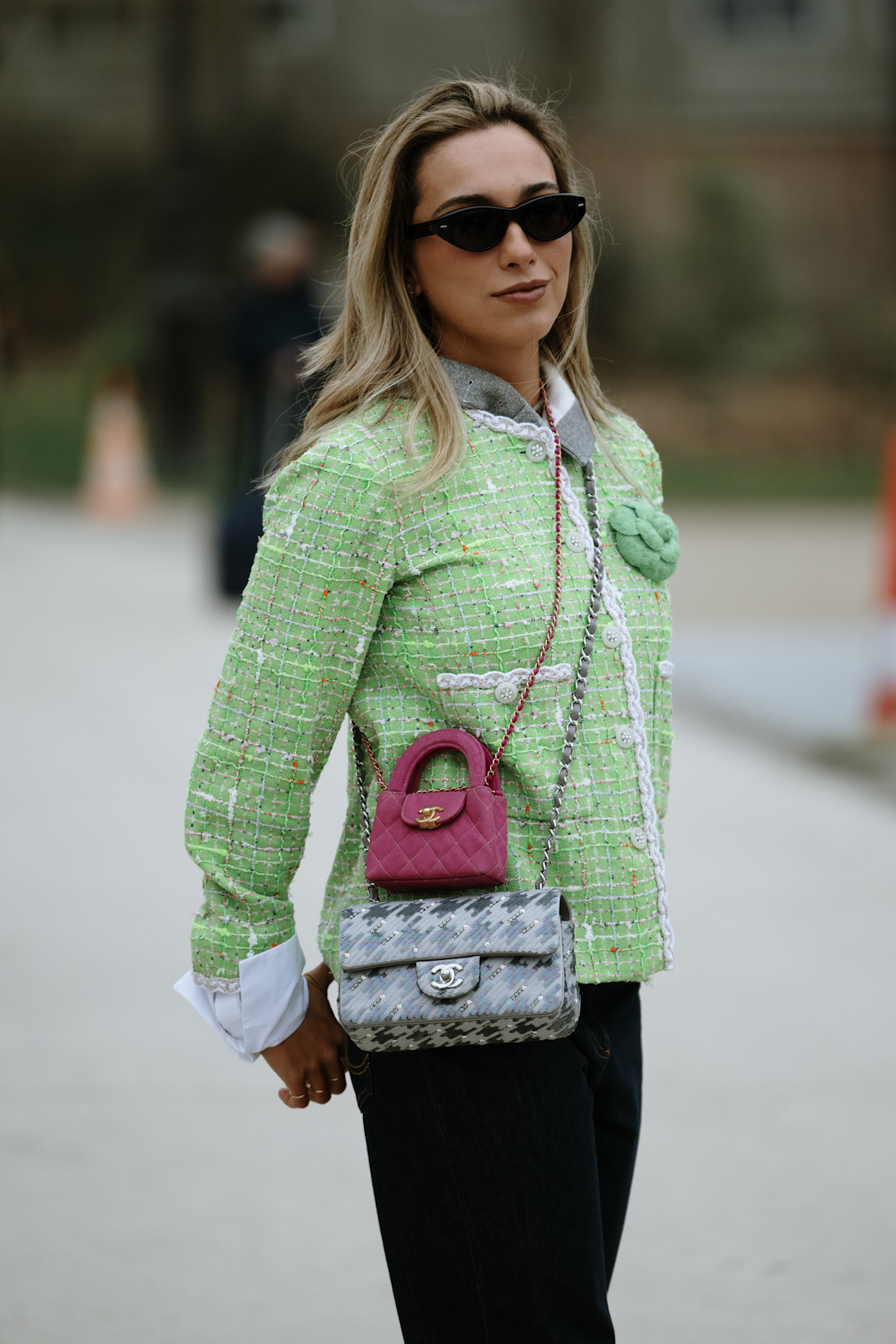 a woman in street style wearing two crossbody Chanel bags at once