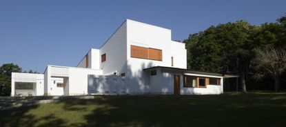 the white, clear, crisp and restored Maison Louis Carré by Alvar Aalto against blue skies