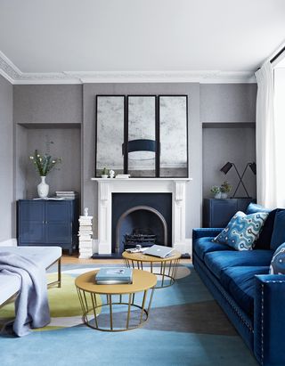 Blue and grey living room with velvet blue sofas and grey walls