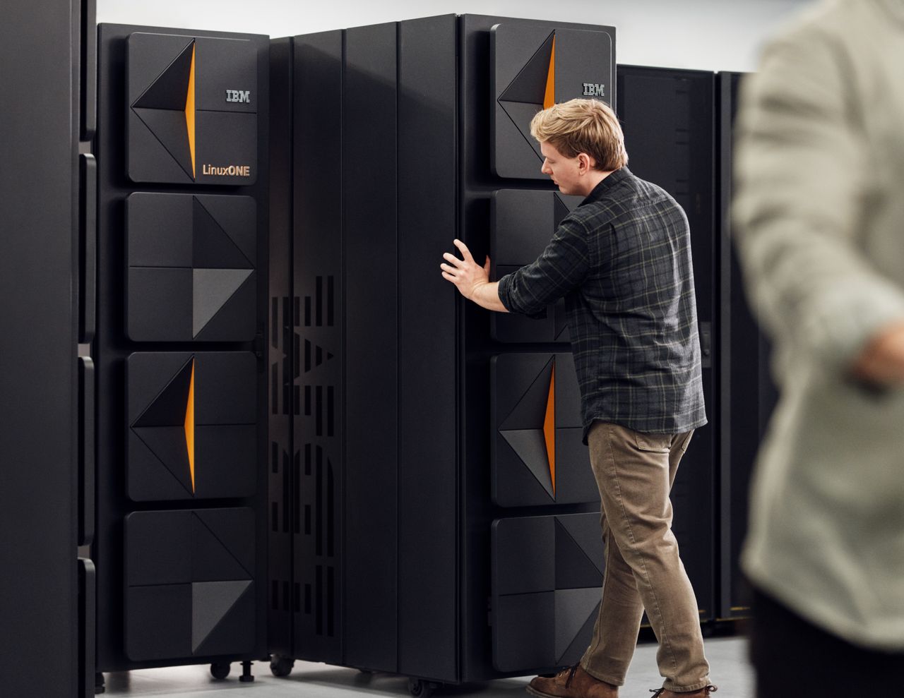 IBM LinuxONE 5 server rack being pushed into position by data center worker.