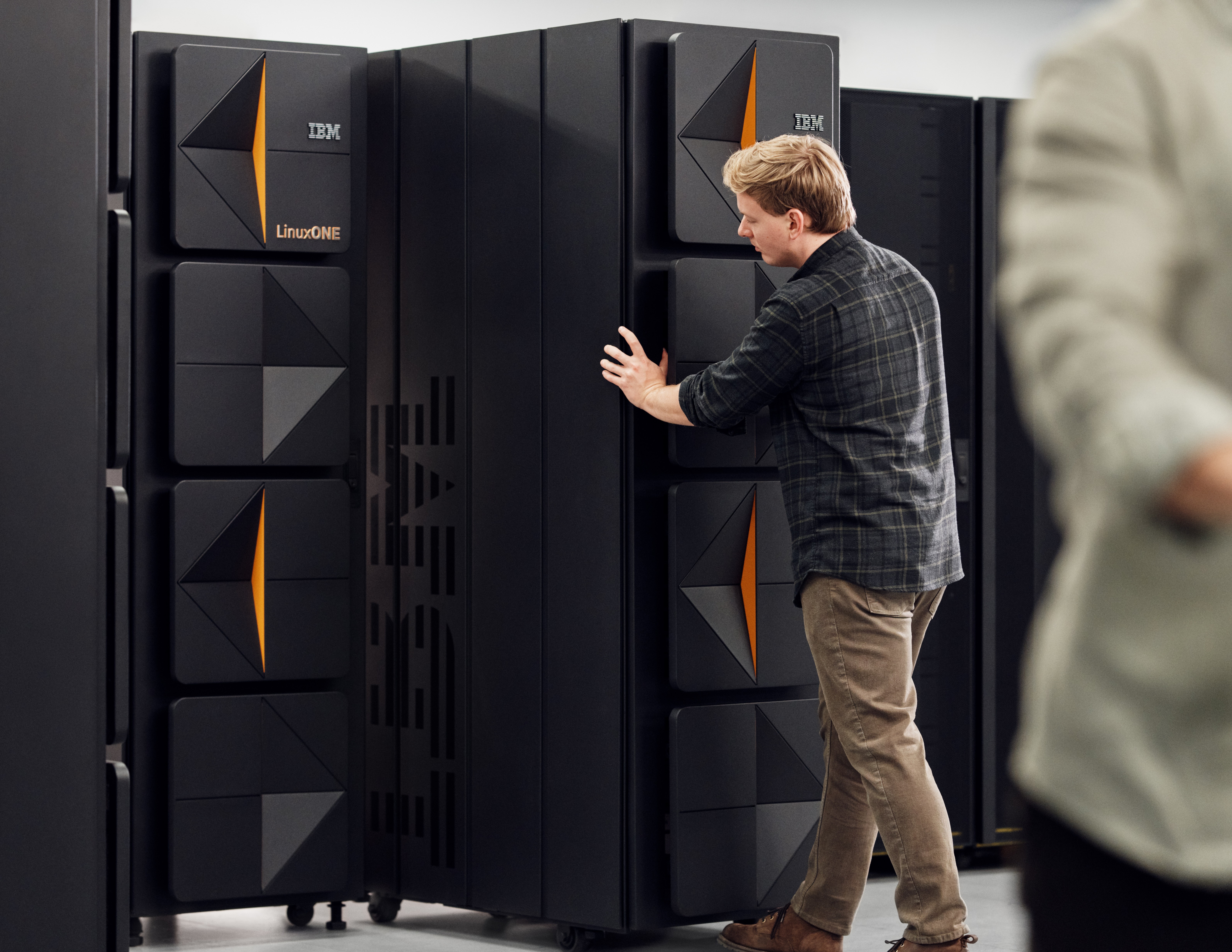 IBM LinuxONE 5 server rack being pushed into position by data center worker.