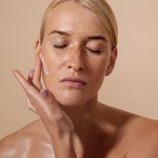 Best serum for pigmentation - woman applying a cream to her skin - getty images 1347066292 