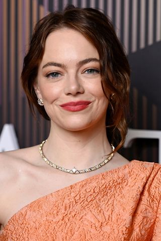 Emma Stone is pictured with dark red/copper hair whilst attending the EE BAFTA Film Awards 2024 at The Royal Festival Hall on February 18, 2024 in London, England.