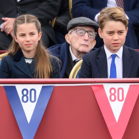Prince George, Prince Charlotte and Prince Louis sitting at a VE Day parade