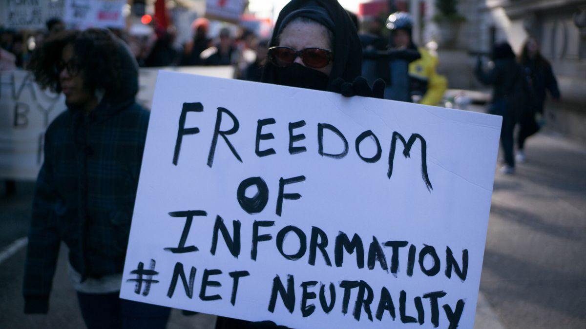 Protestor holding sign reading &amp;quot;Freedom of information, Net Neutrality&amp;quot;, at a rally for net neutrality on the streets of Philadelphia in January 2018.