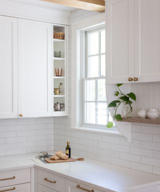 A white kitchen with shelving designed into the cabinets