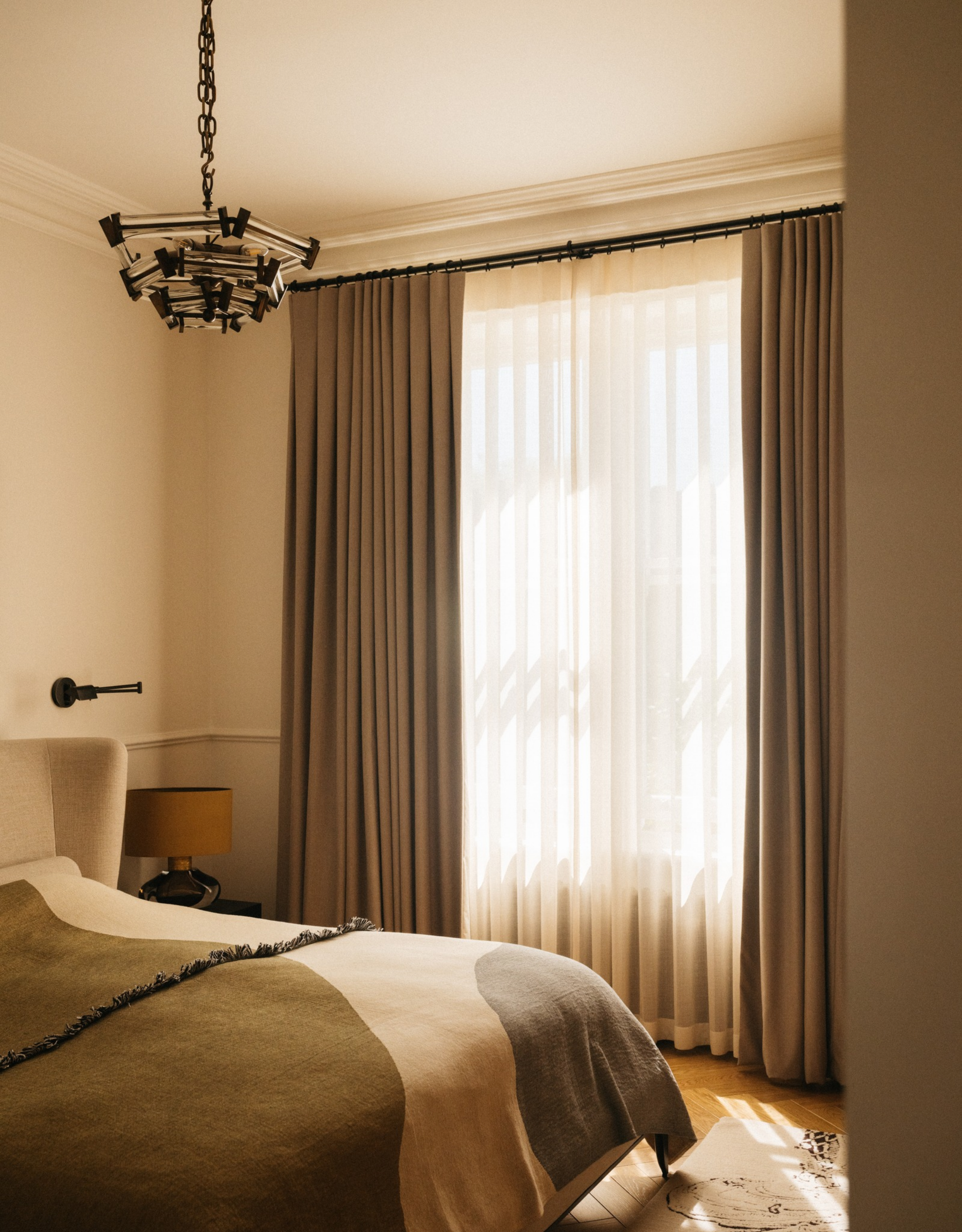 neutral and light bedroom with light brown curtains and a cream bed