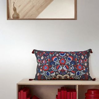 white room with decorative pillow on wooden shelf