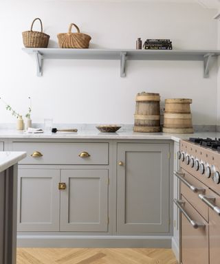 pale gray Shaker cabinets, with white walls, warm toned wood floor, open shelving