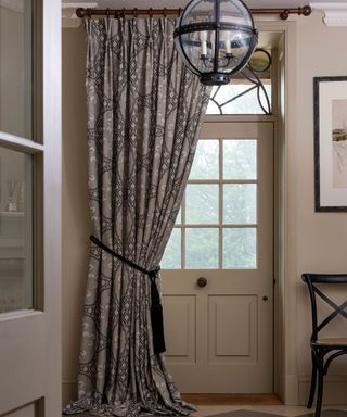 Hallway with front door covered with door curtain, metal and glass rounded pendant light, black & white checkered flooring