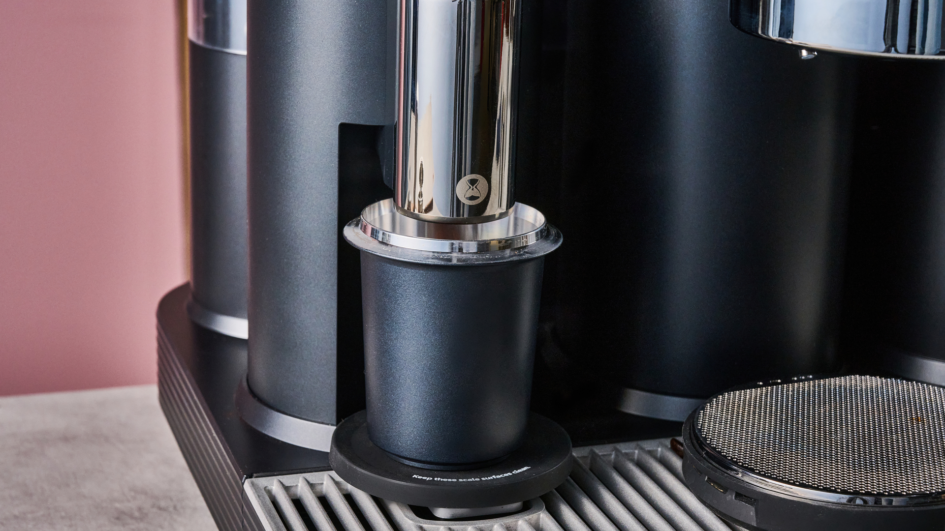 A closeup of the Meraki Espresso Machine's grinder and dosing cup.