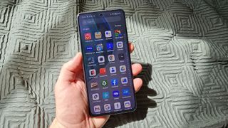 OnePlus Nord CE 4 Lite holdes op foran et lysegrønt gardin.