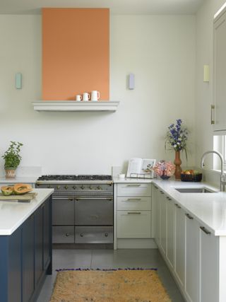 White kitchen with blue island and orange painted induction fan