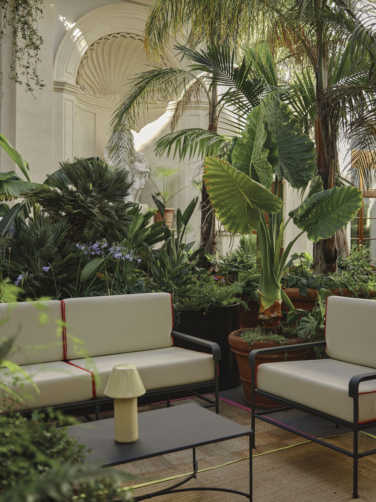 a garden filled with mid-century modern furniture and plants.