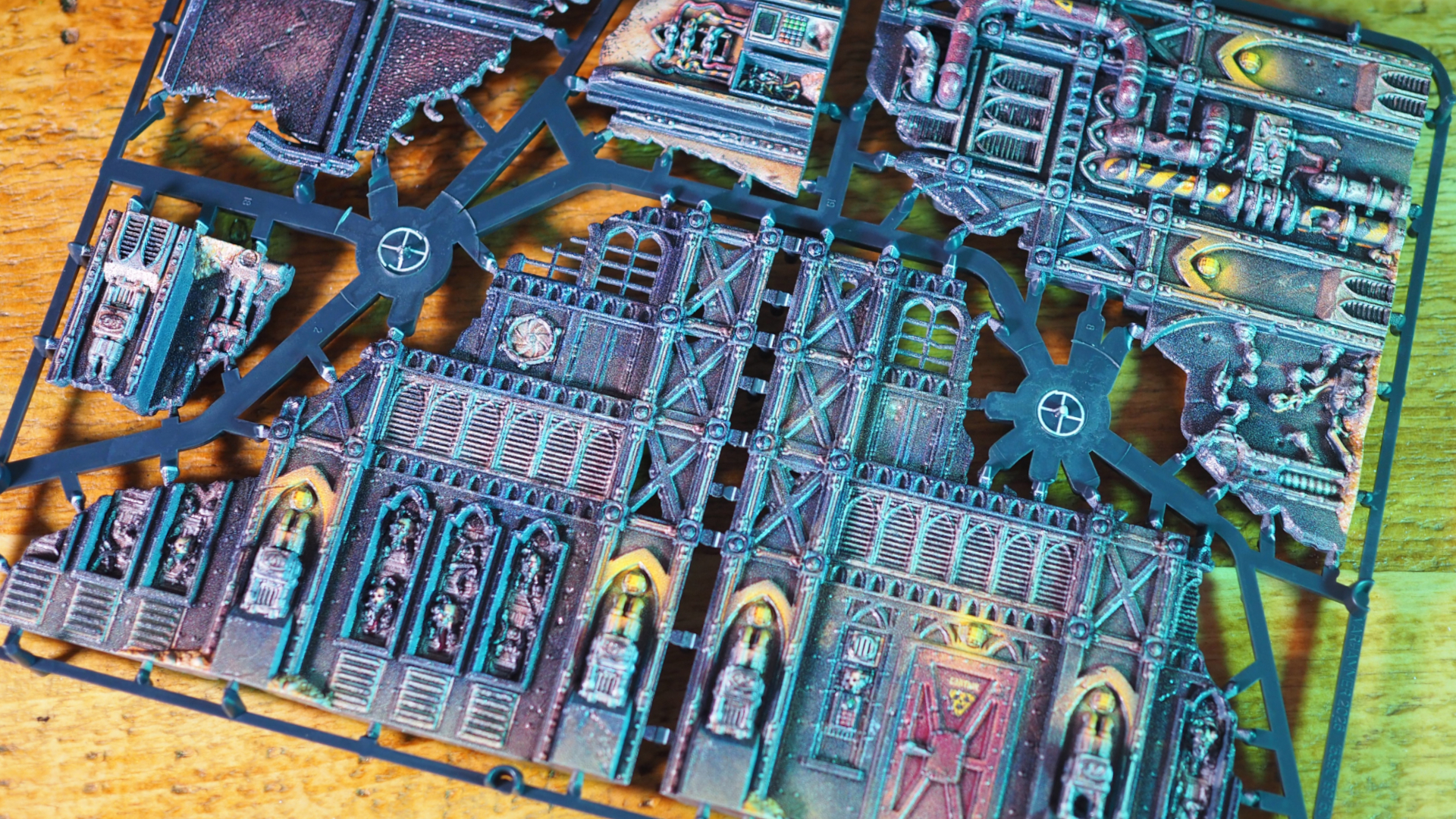 Warhammer 40,000 pre-painted terrain on sprues, lying on a wooden table