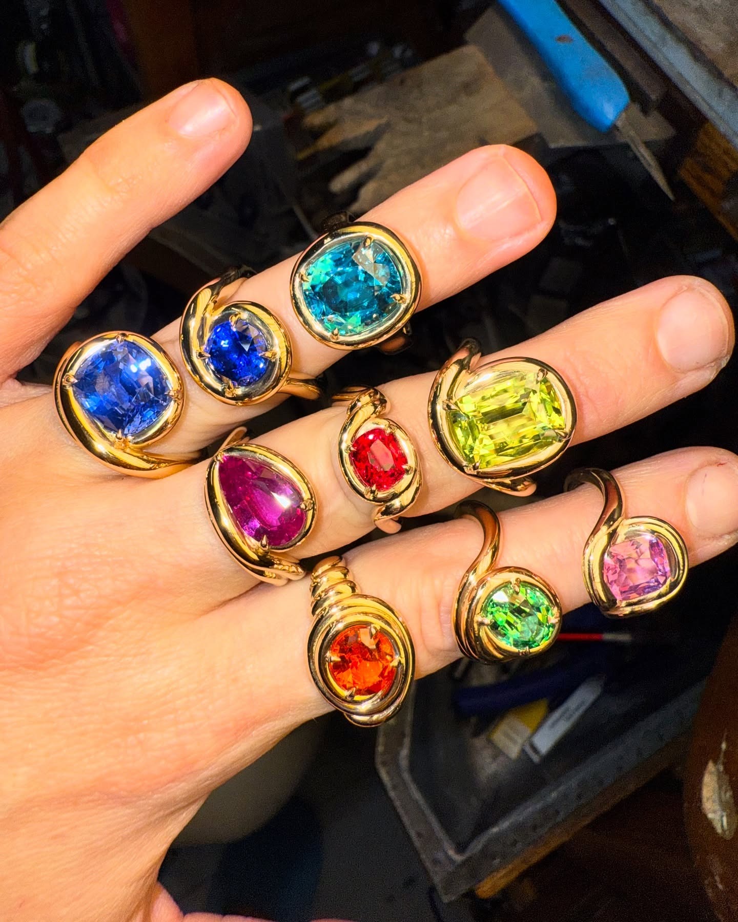 Jeweler wearing different fine colored gemstone jewelry rings.