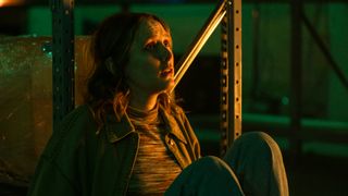 Alison sits on the floor in Code of Silence