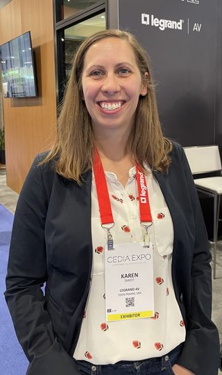 A Legrand | AV member smiling at its CEDIA 2023 booth.