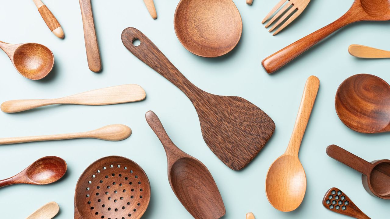 A selection of wooden utensils on a blue kitchen countertop