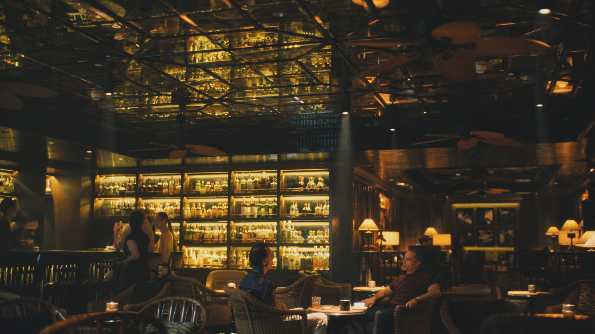 Walton Goggins and Sam Rockwell sit in a low lit bar