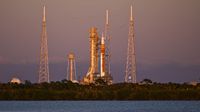 A photo of the Artemis II rocket sitting on a launchpad at Kennedy Space Center in Cape Canaveral, Florida, at sunset. 