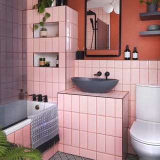 Pink-tiled bathroom with plants