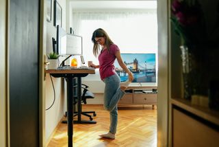 Woman working at home is stretching