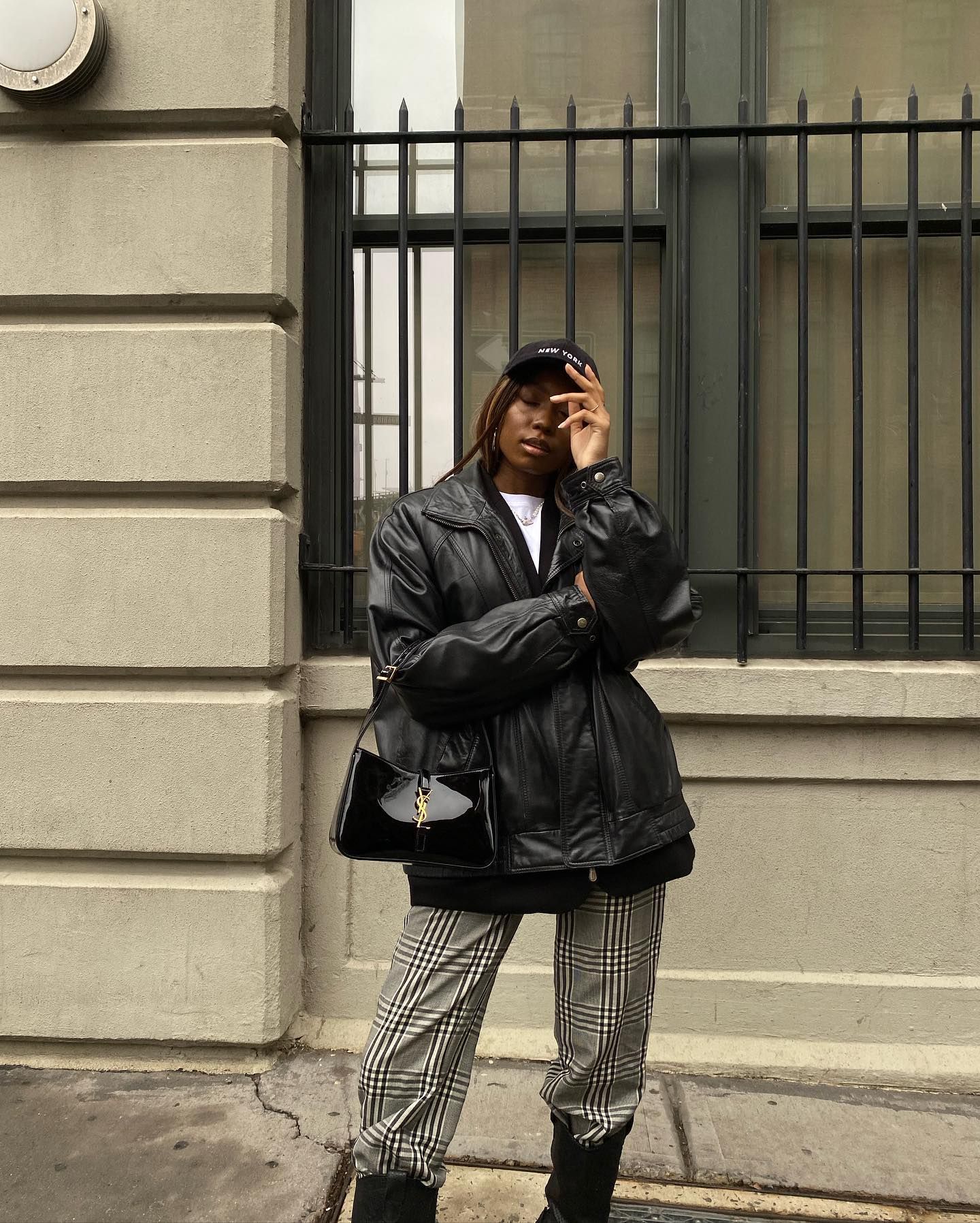 Woman wears leather jacket, plaid trousers and black boots