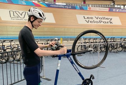 Track cyclist at Lee Valley Velodrome holding a track bike