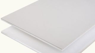 Grey insulating plasterboard on plain background