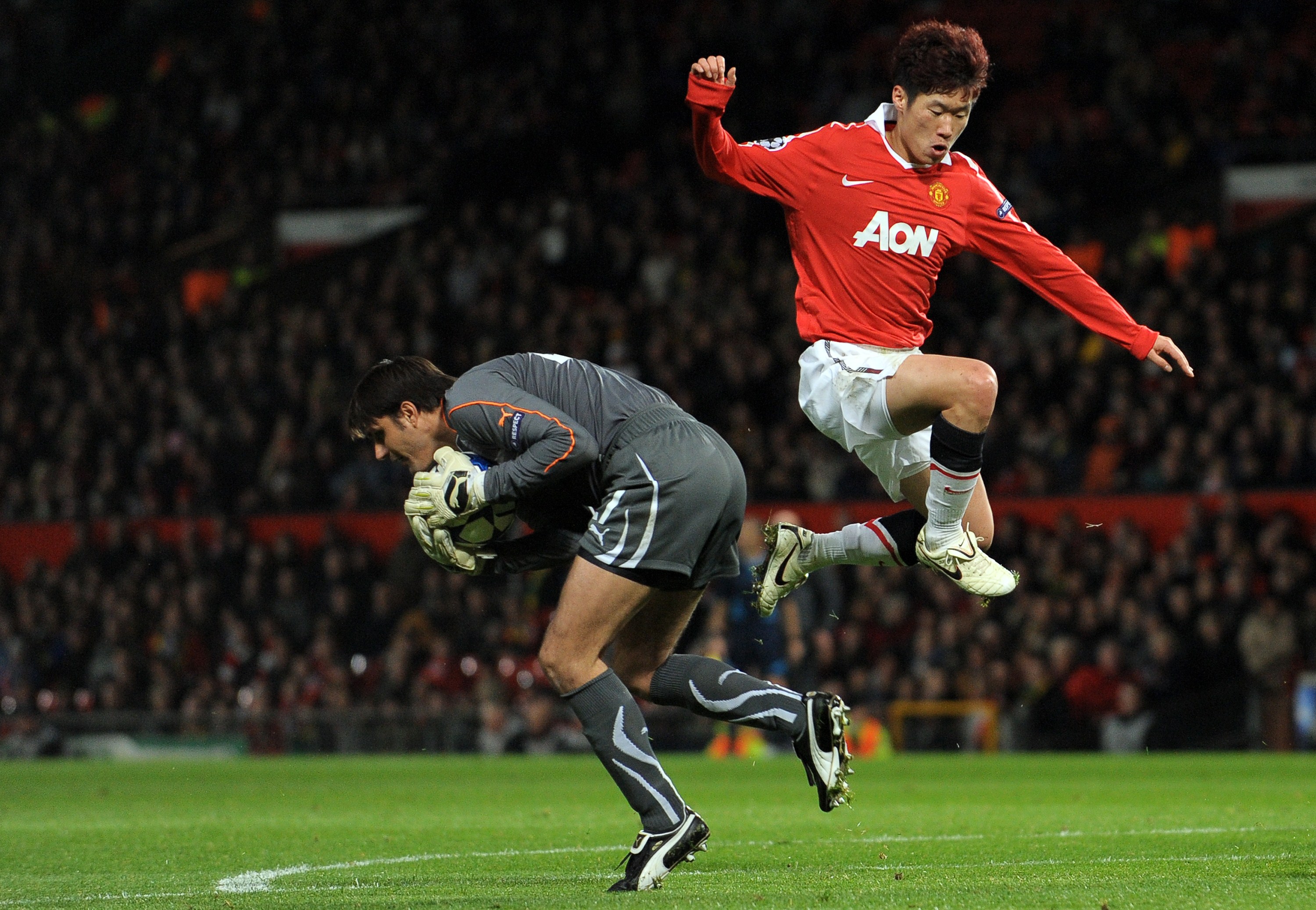 Bursaspor goalkeeper Dimitar Ivankov beats Manchester Unted's Park Ji-sung to the ball in October 2010.