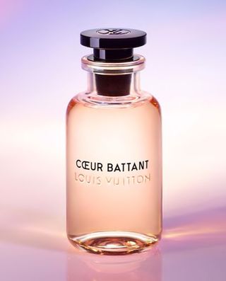Bottle of coeur battant perfume against a light purple and pink background