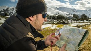 how does a magnetic compass work: hiker taking a bearing