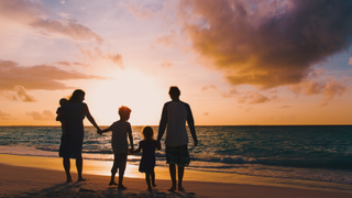 family on beach at sunset
