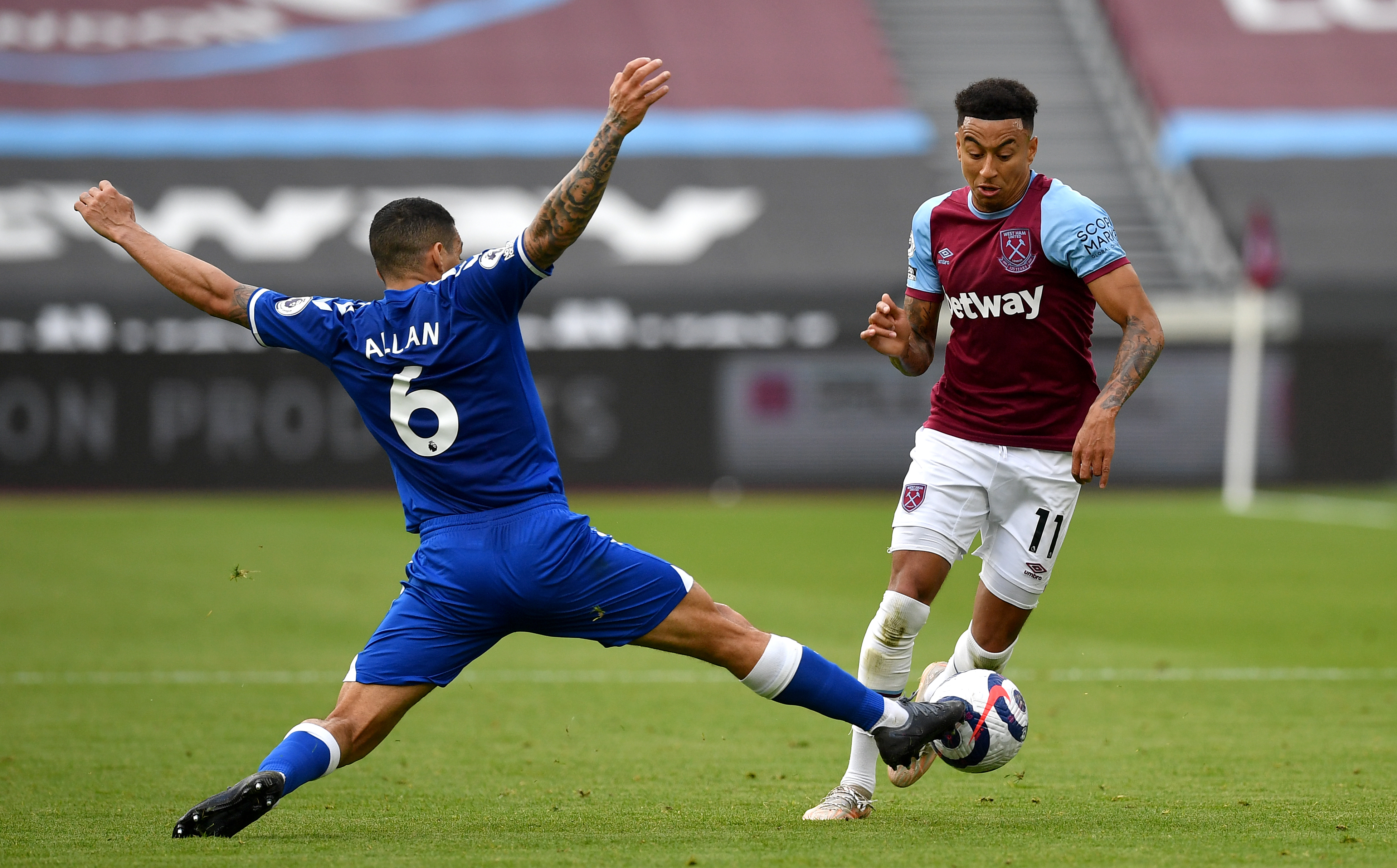 Jesse Lingard, right, is tackled by Everton's Allan