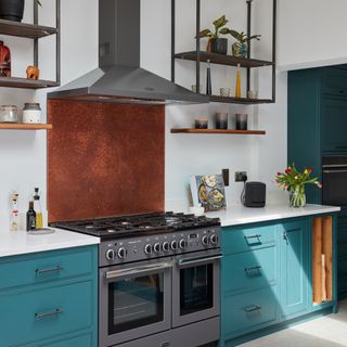Copper kitchen splashback in a teal kitchen with white worktops
