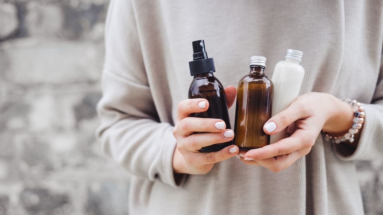 Close up of woman&#039;s hands holding skincare products