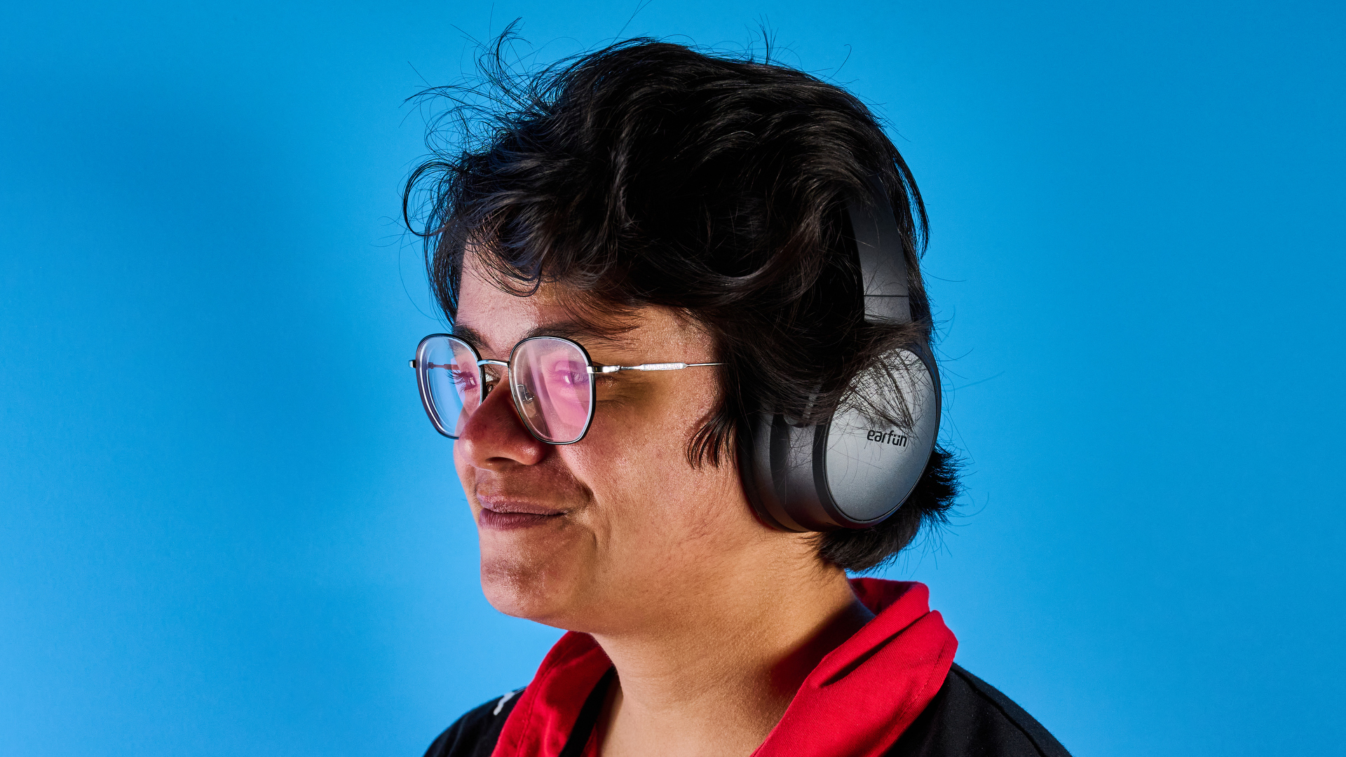 the earfun tune pro headphones, in black, with soft pleather cups, and gray cups, photographed against a blue background