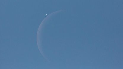 An image of the moon and Venus in a blue sky.