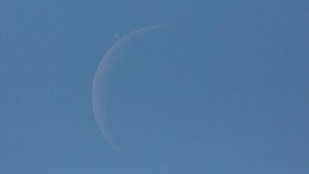 An image of the moon and Venus in a blue sky.
