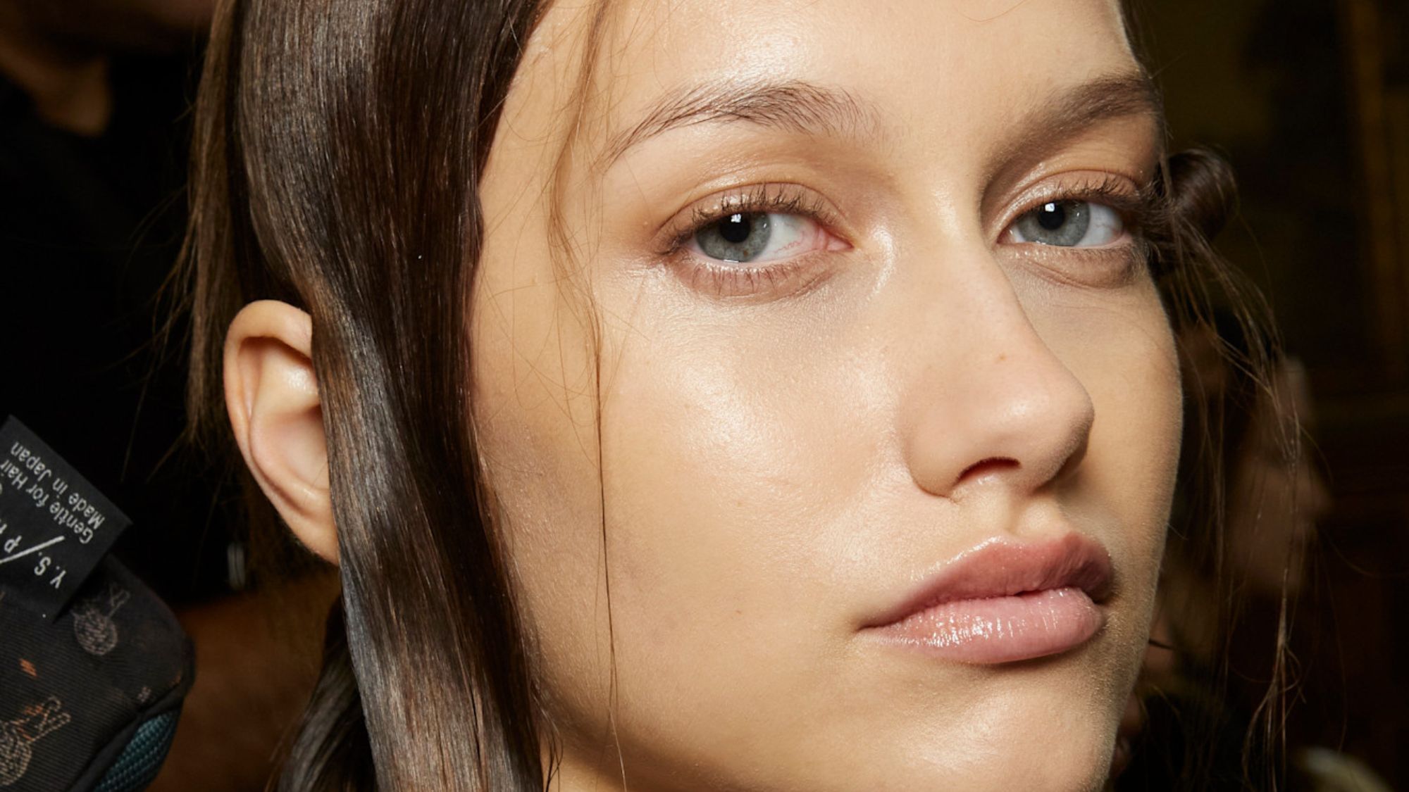 model backstage looking at the camera with glowy skin