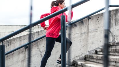 Woman running up a set of steps outside